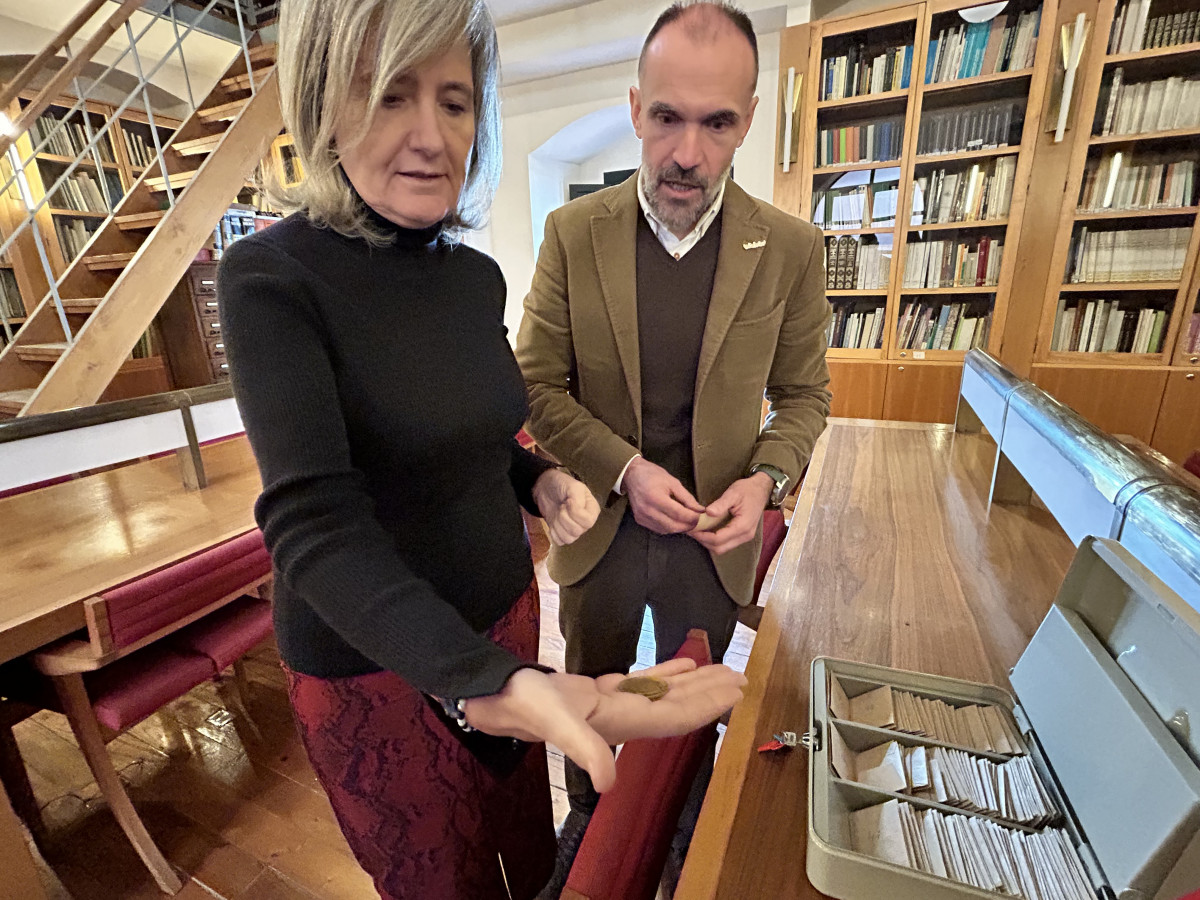 La consejera bazaga muestra una de las monedas del tesoro