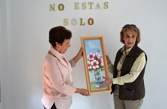 La pintora Puerto Encinas entrega a AOEX Plasencia un cuadro para el próximo mercadillo benéfico